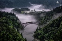 تصویر تماشایی عبور قطار بر فراز دره ای مه آلود