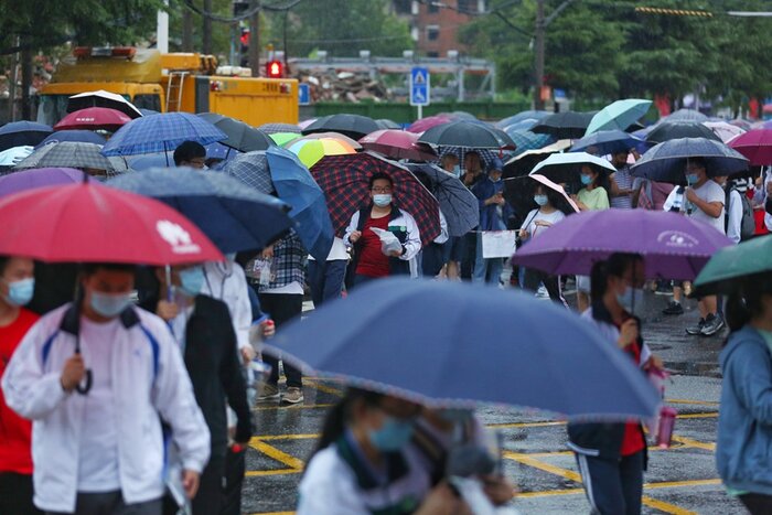  صف داوطلبان برای ورود به آزمون کنکور زیر باران در ووهان، کانون اولیه شیوع کرونا در چین